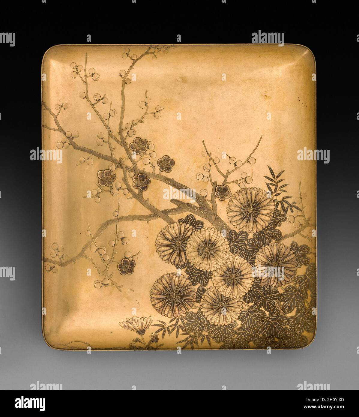 Lid of Writing Box (Suzuribako) with Chrysanthemum and Plum, late 1800s-early 1900s. Japan. Lacquer over wood with gold and silver sprinkled powder (maki-e);  Both functional and elegant, this is a container for an ink stone, brushes, and ink from a set of writing tools that included a larger box for paper. Against a sleek gold lacquered ground, its artist has used restraint in sprinkled powder decoration (maki-e) to produce the design of cockscomb and harvested rice on the interior of the lid. Stock Photo