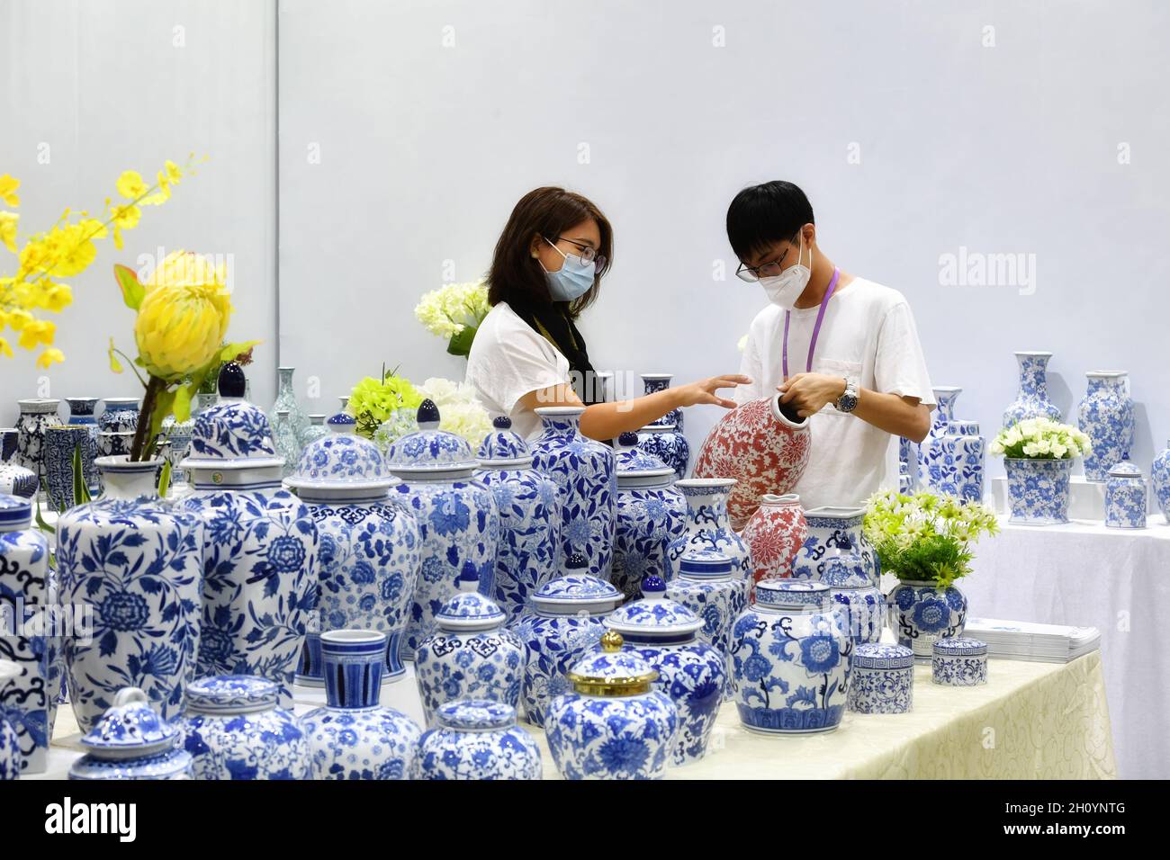 (211015) -- GUANGZHOU, Oct. 15, 2021 (Xinhua) -- A buyer (L) talks with a porcelain exhibitor during the 130th session of the China Import and Export Fair, also known as the Canton Fair in Guangzhou, south China's Guangdong Province, Oct. 15, 2021.  The five-day session kicked off here on Friday. It's the first time the fair is held online and offline concurrently.   Nearly 8,000 global enterprises will participate in offline exhibitions of the fair. Meanwhile, around 26,000 companies from home and abroad will participate online, with a record number of 2.82 million exhibits submitted. (Xinhua Stock Photo