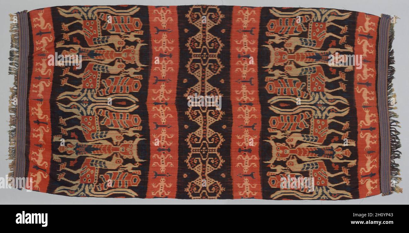 Hinggi, early 1900s. Indonesia, Sumba, early 20th century. Cotton, ikat dyed; overall: 239.4 x 117.2 cm (94 1/4 x 46 1/8 in.).  On the Indonesian island of Sumba, hinggi were one of two types of textiles that were worn for ritual ceremonies and used as exchange gifts required on occasions of birth, marriage, or death. Traditionally, their designs reflect the religious and social structure of Sumbanese culture. The abstract motif in the center of this mantle represents an open shellfish, symbolic of royal power. The crocodile, seen here in the red bands to either side of the central band, is al Stock Photo
