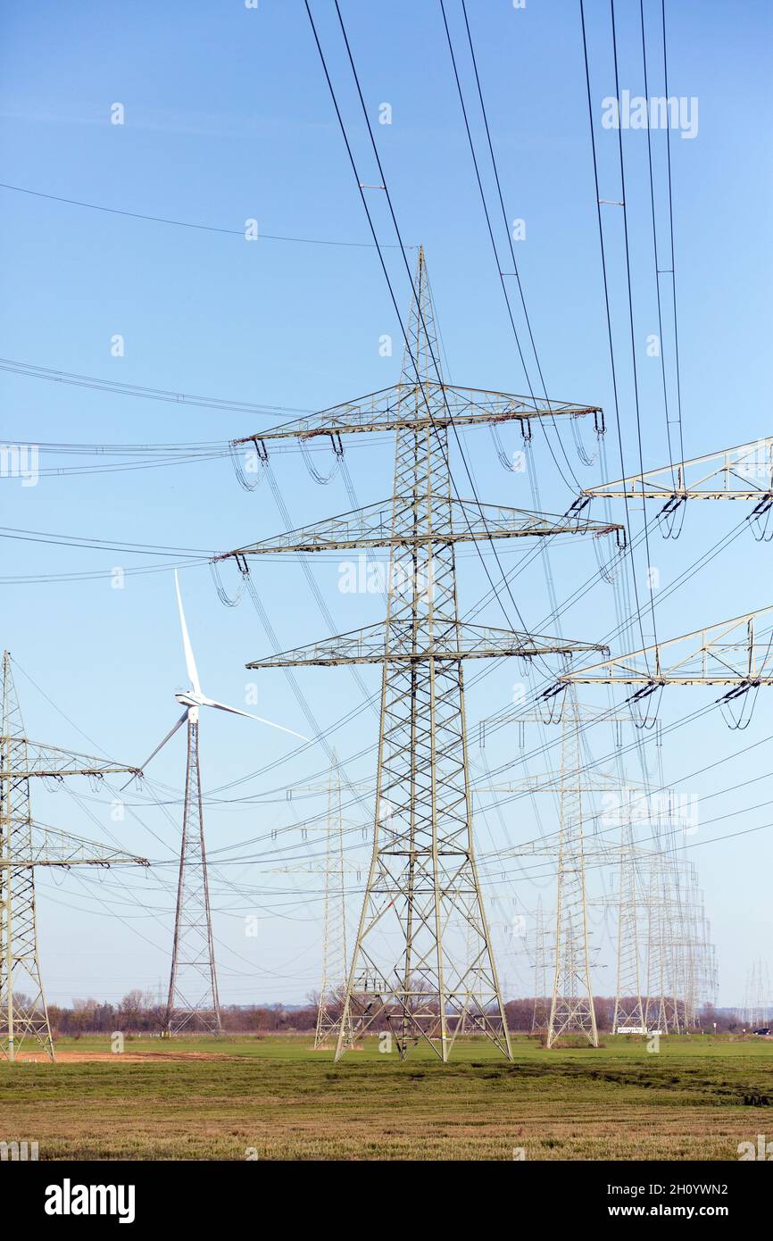 Large Power Line With High-voltage Pylons, Power Lines And A Wind Power Plant. Wind Energy, Power Line Stock Photo