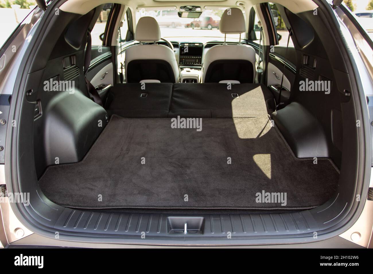 Huge, clean and empty car trunk of a modern compact suv. Rear view of a SUV car with open trunk and folded passenger seats. Stock Photo