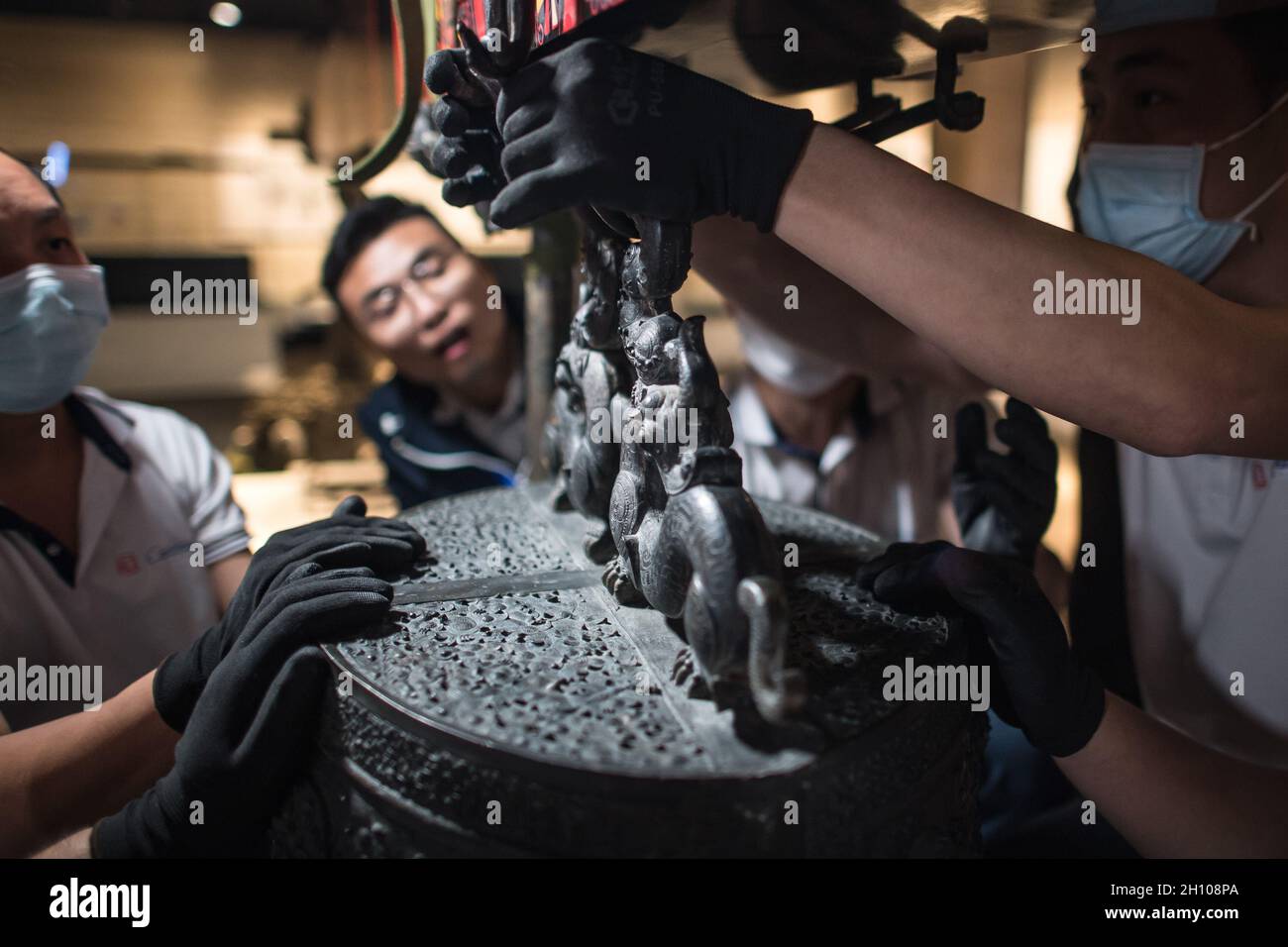 (211015) -- WUHAN, Oct. 15, 2021 (Xinhua) -- Staff members adjust chime bells after they were transferred to a newly-built exhibition hall of Hubei Provincial Museum in Wuhan, central China's Hubei Province, Oct. 14, 2021. The set of chime bells were recently relocated to the newly-built third phase project of the museum. Chime bell, or bian zhong in Chinese, is a percussion instrument that became prevalent in China from the Western Zhou Dynasty (1046-771 B.C.). Credit: Xinhua/Alamy Live News Stock Photo