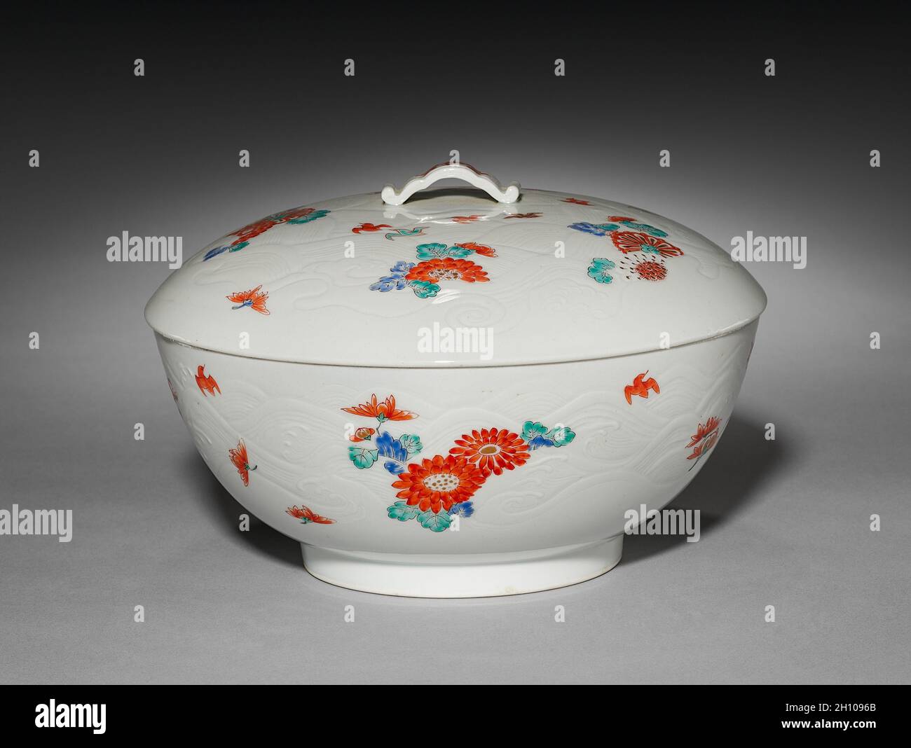 Covered Bowl with Chrysanthemums and Chidori: Kakiemon Ware, early 1700s. Japan, Edo period (1615-1868). Porcelain with decoration in colored enamels; molded design of waves on exterior; diameter: 21 cm (8 1/4 in.); with cover: 12.7 cm (5 in.); without cover: 9 cm (3 9/16 in.). Stock Photo