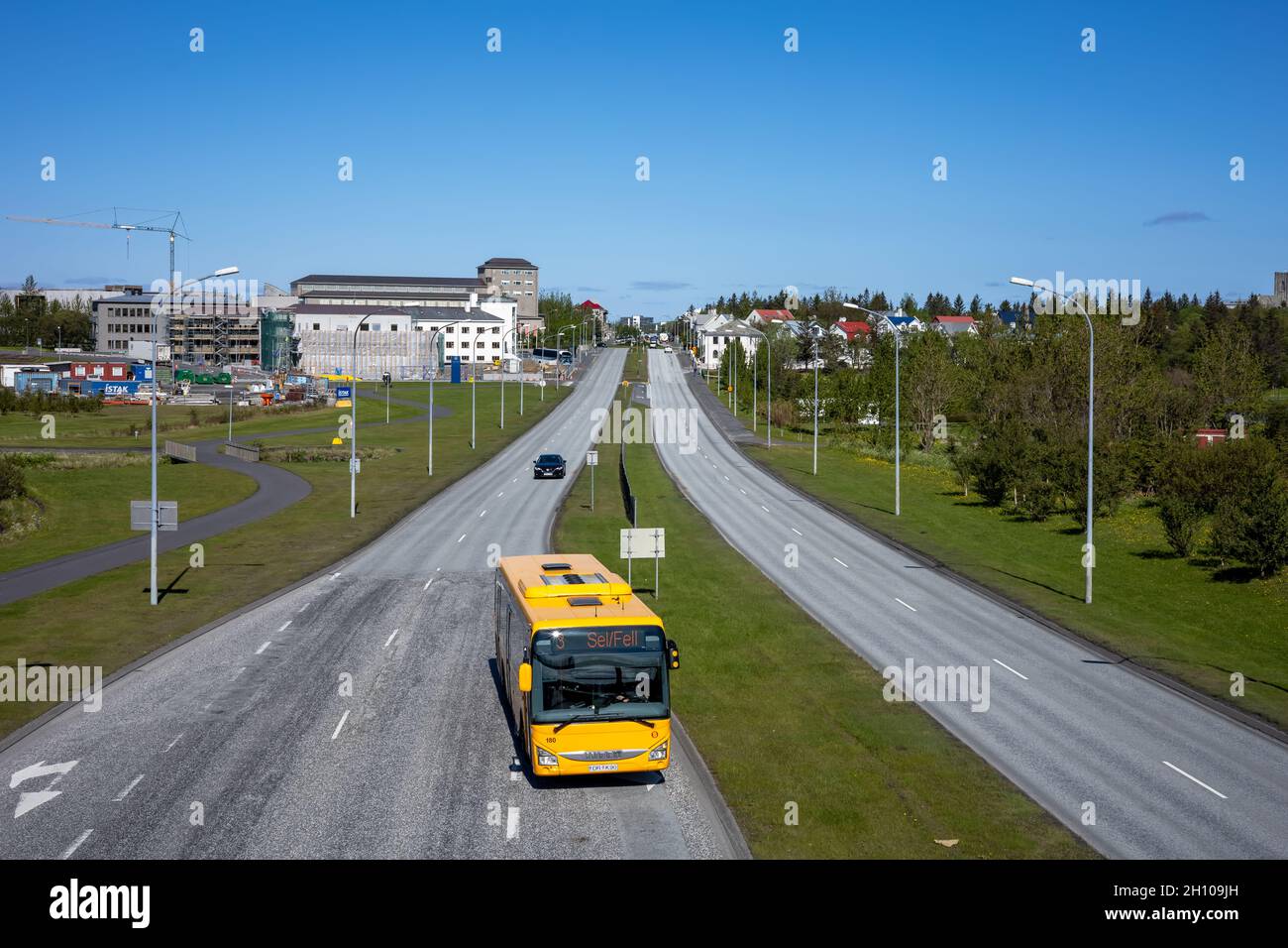 REYKJAVIK, ICELAND - June 12, 2021: A view from a Njardargata overpass to Hringbraut road. Scarce car traffic and a yellow city bus. Stock Photo