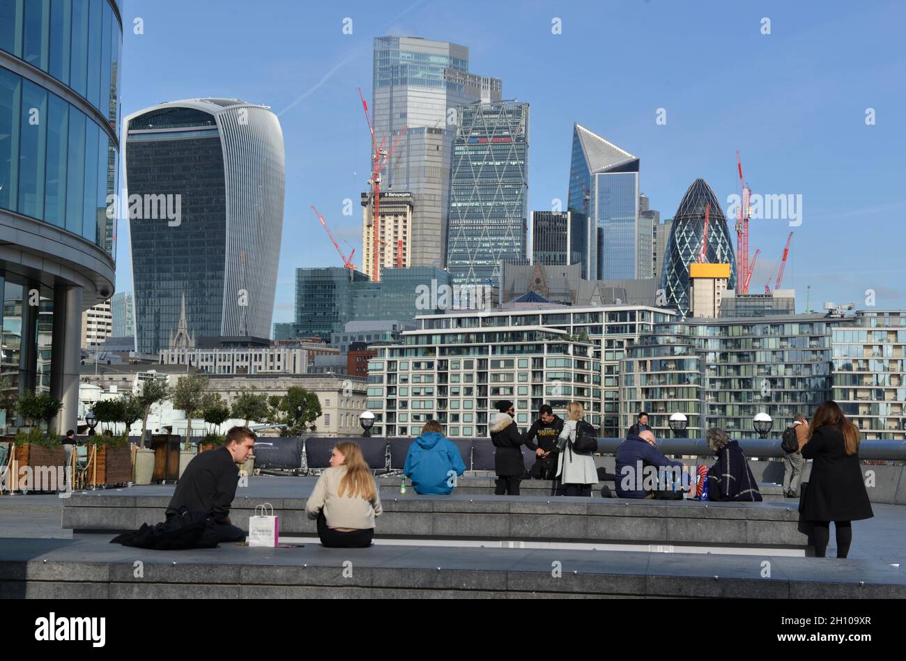 People sitting and watching the City of London skyline as seen from ...