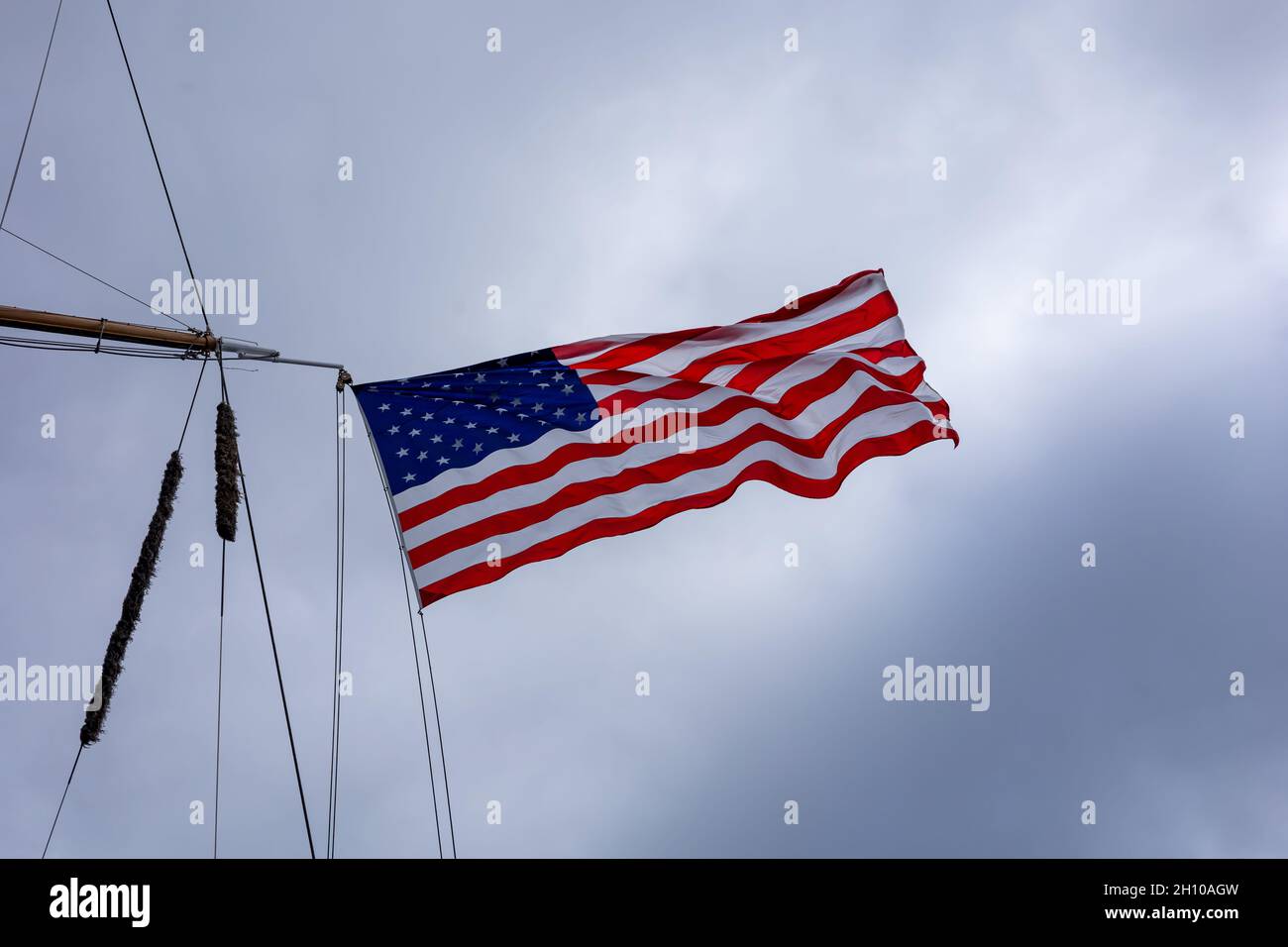 A national flag of United States of America, fluttering in the wind on the ship mast. Stock Photo