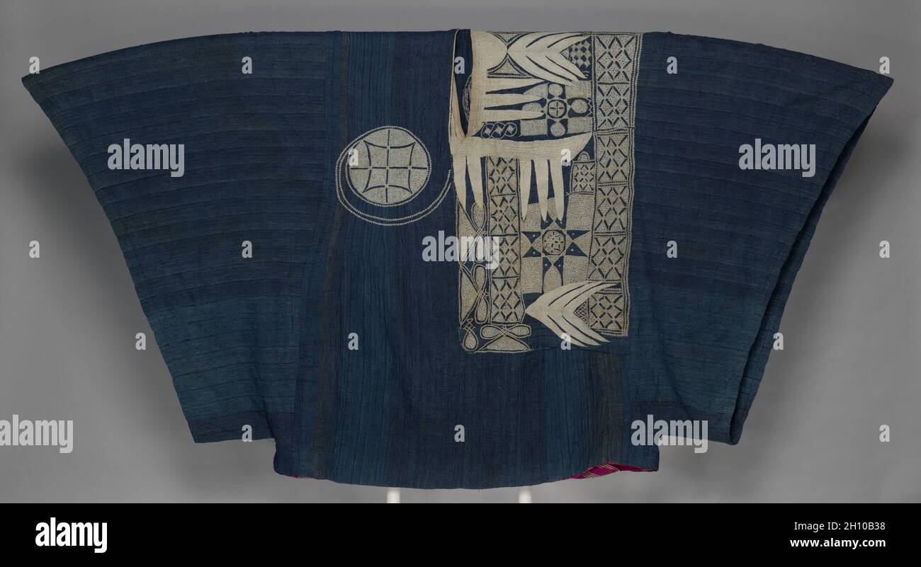 Prestige robe (riga), late 1800s–by 1910. Africa, West Africa, Nigeria, probably Hausa-style or Nupe-style weavers and embroiders. Cotton, silk, and indigo; overall: 120 x 226 cm (47 1/4 x 89 in.).  Elite Nigerian men wore voluminous status garments variously called riga (Hausa), agbádá (Yorùbá), boubou (French), or mbubb (Wolof). Punctuated with white silk, this strip-woven riga’s inky blue was achieved by repeatedly dipping threads into indigo dye before weaving them. Embroiderers were often skilled Arabic calligraphers; the motifs here once had protective Islamic symbolism. The front pocket Stock Photo