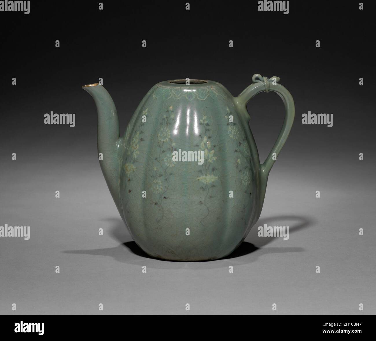 Melon-shaped Ewer with Incised Peony Design, 918-1392. Korea, Goryeo period (918-1392). Pottery; vessel only: 20.4 cm (8 1/16 in.).  This melon-shaped pitcher is adorned with a delicate drawing that renders chrysanthemum buds with full blossoms in white and black inlays. In Korea, chrysanthemum flowers and leaves were made into both tea and wine. Chrysanthemum wine was enjoyed during the the Double Nine Festival (the ninth day of the ninth month in the lunar calendar) when praying for longevity. Stock Photo