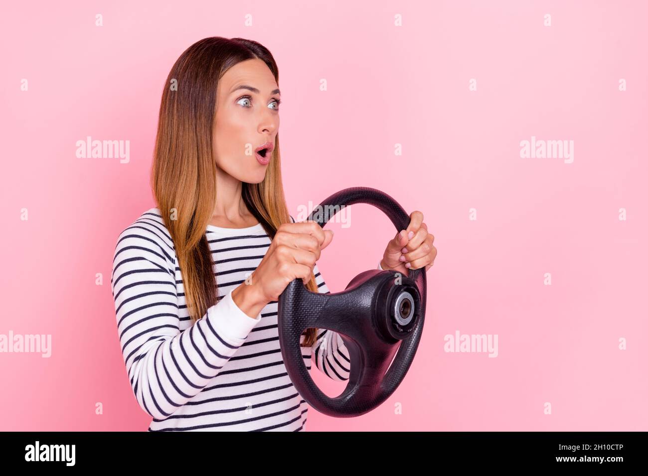 Photo of impressed young woman dressed striped pullover driving car