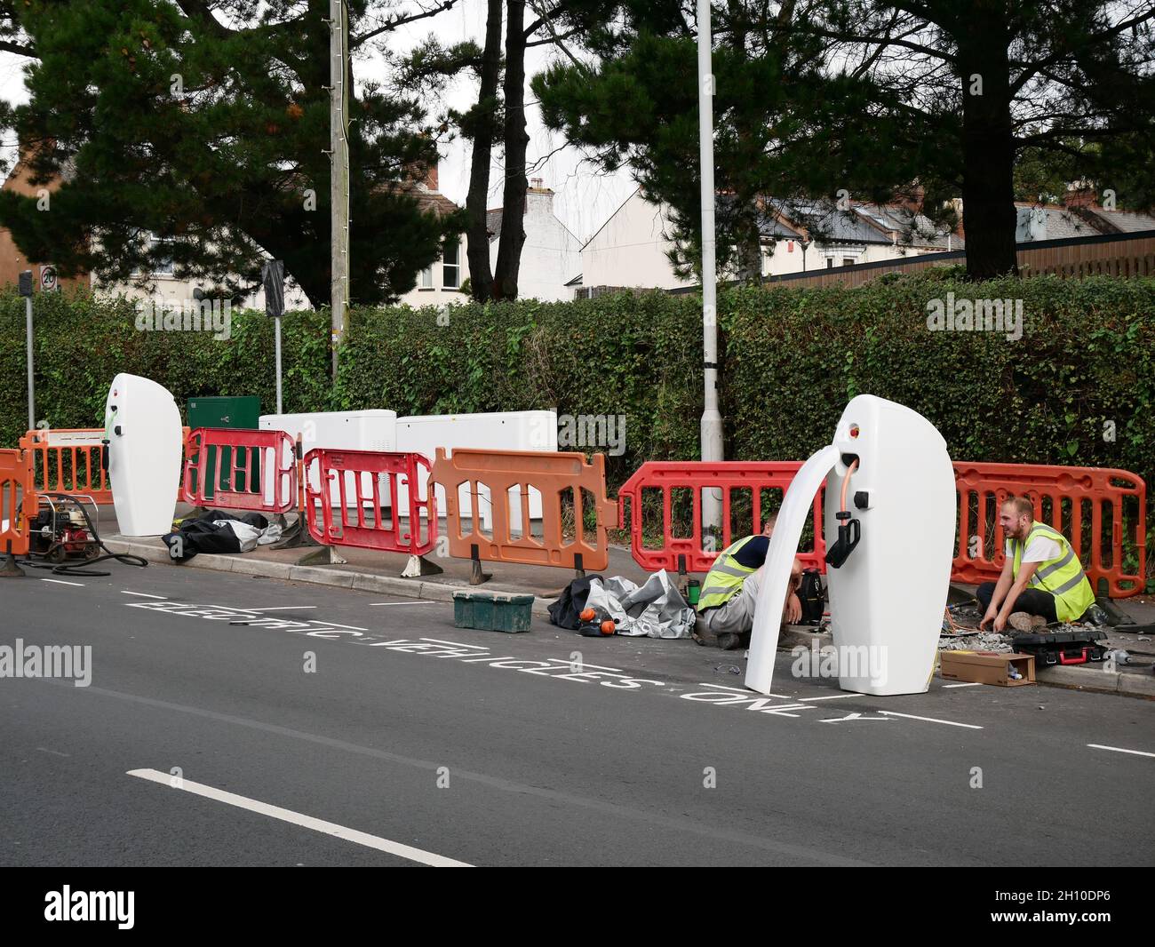Contractors installing kerbside electric vehicle charging points on a street in Exeter, Devon UK Stock Photo