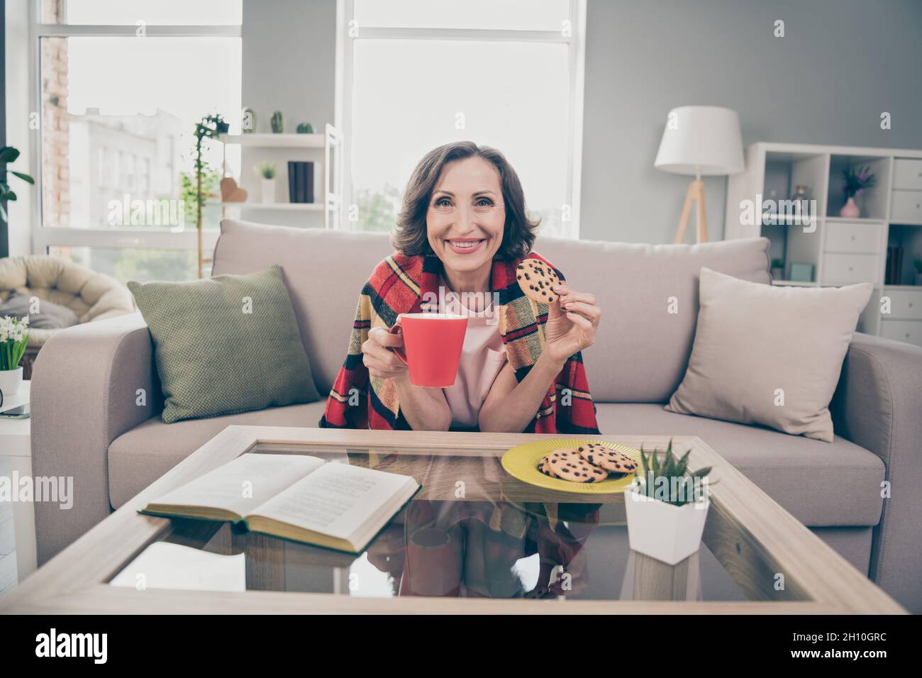 Photo portrait senior woman sitting on couch drinking coffee eating