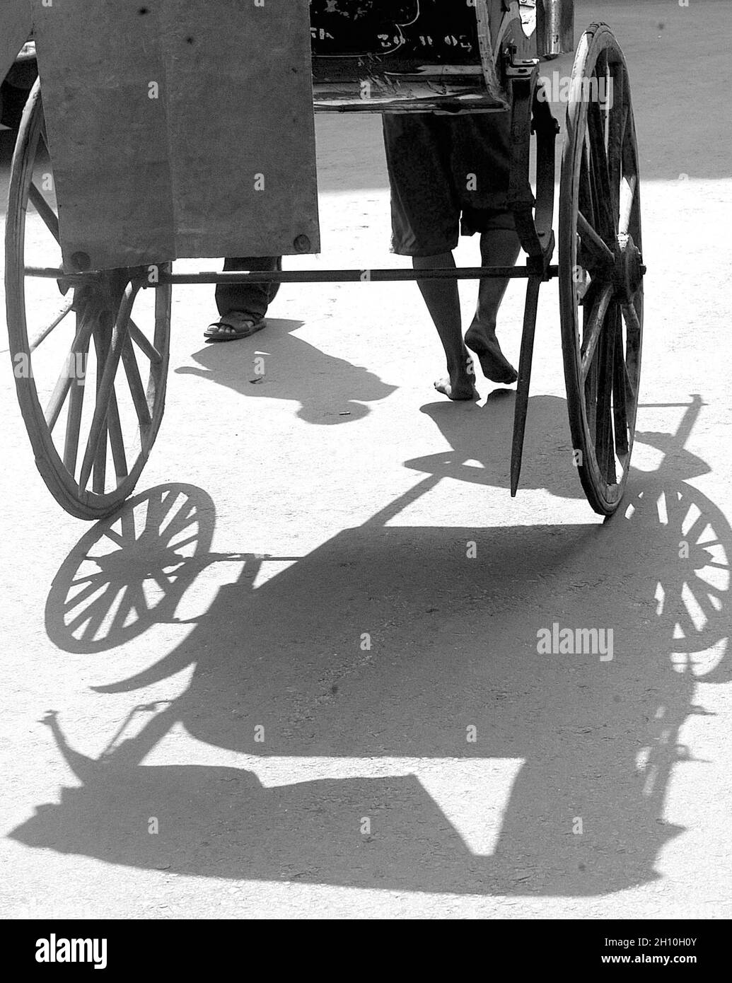 In the chiaro-scuro of existence: For the rickshaw-pullers of Kolkata, the difference between joy and sorrow is defined by the number of passengers they get during the day. If it has been a good day on the street, it means a square meal for him and his family. But a bad day may end with little or nothing on the plate. The hand-pulled rickshaw is probably as old as Kolkata. Since the days of The Raj, it has pulled people to their destinations through the winding alleys of the city. It is the chosen mode of transport for elderly people especially in the monsoons when waterlogged streets slow dow Stock Photo