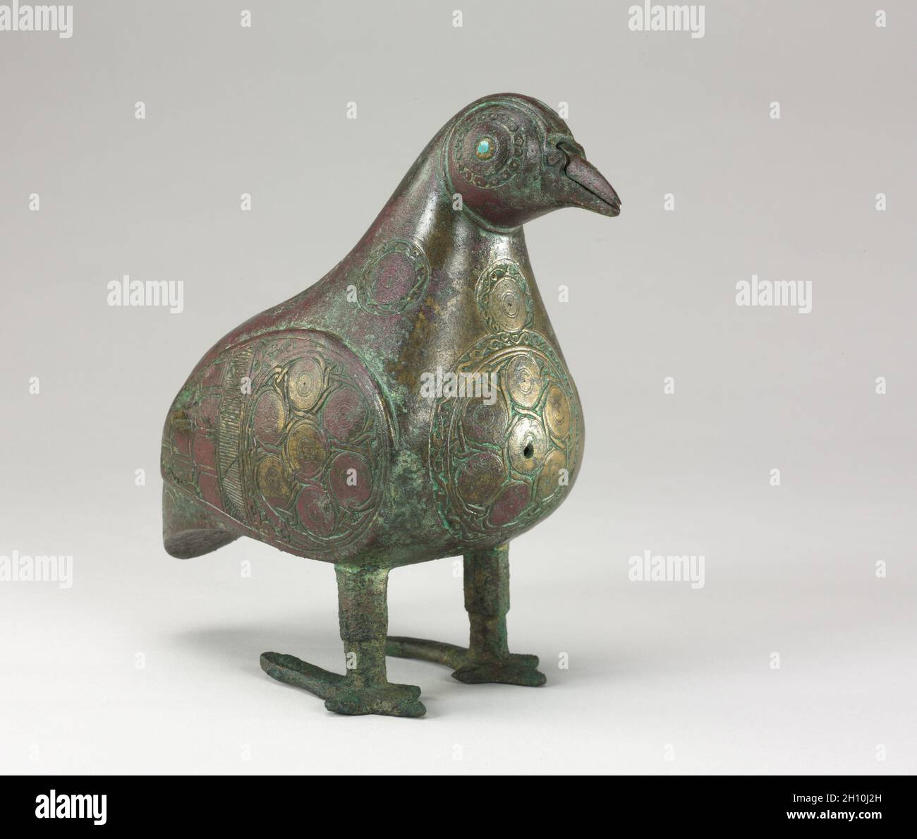 Bird-shaped Vessel, 1100s. Iran, Seljuq period (1037–1194). Bronze, cast, with chased and chiseled decoration; eyes inlaid with blue glass; overall: 17.5 x 9.5 cm (6 7/8 x 3 3/4 in.). Stock Photo