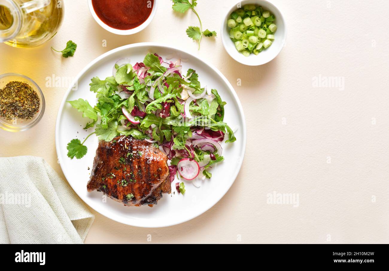 roasted-pork-steak-with-salad-from-fresh-vegetables-over-light-stone