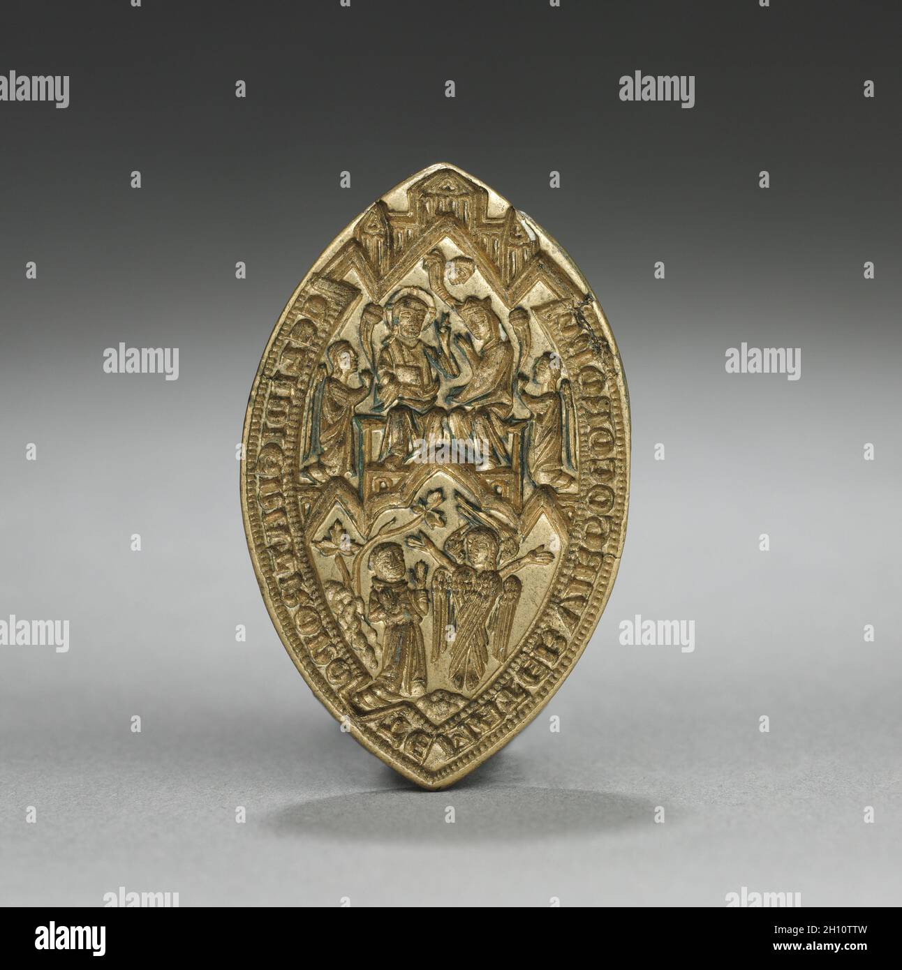 Almond-Shaped Seal: Coronation of the Virgin with a Kneeling Monk, 1300s. England or Germany, Gothic period, 14th century. Gilded bronze; overall: 3.9 x 2.6 cm (1 9/16 x 1 in.). Stock Photo