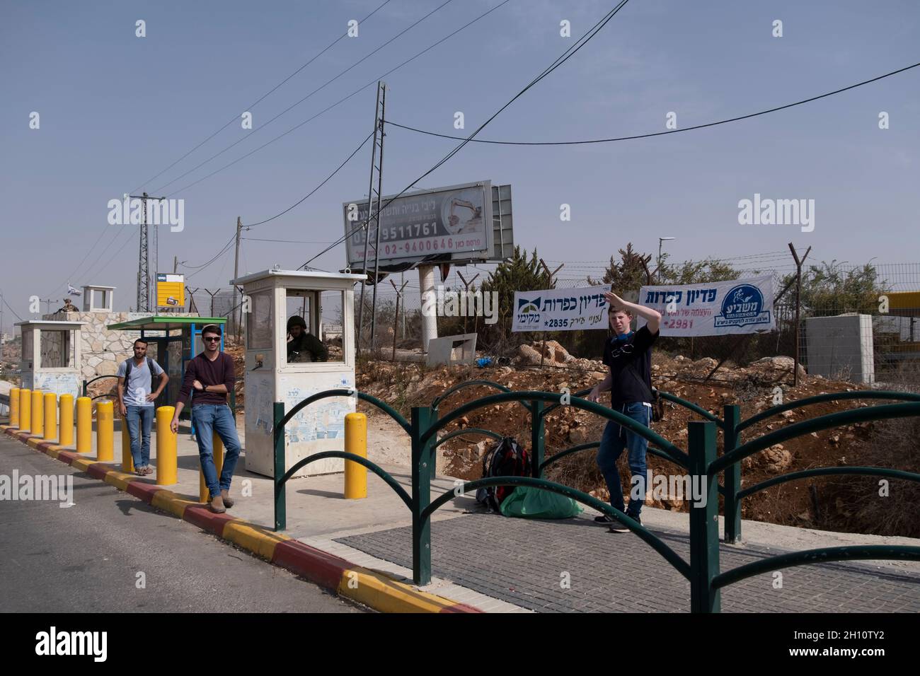 An Israeli soldier stands guard behind concrete block at a bus station at the entrance to the Jewish settlement of Ofra in the West bank Israel Stock Photo