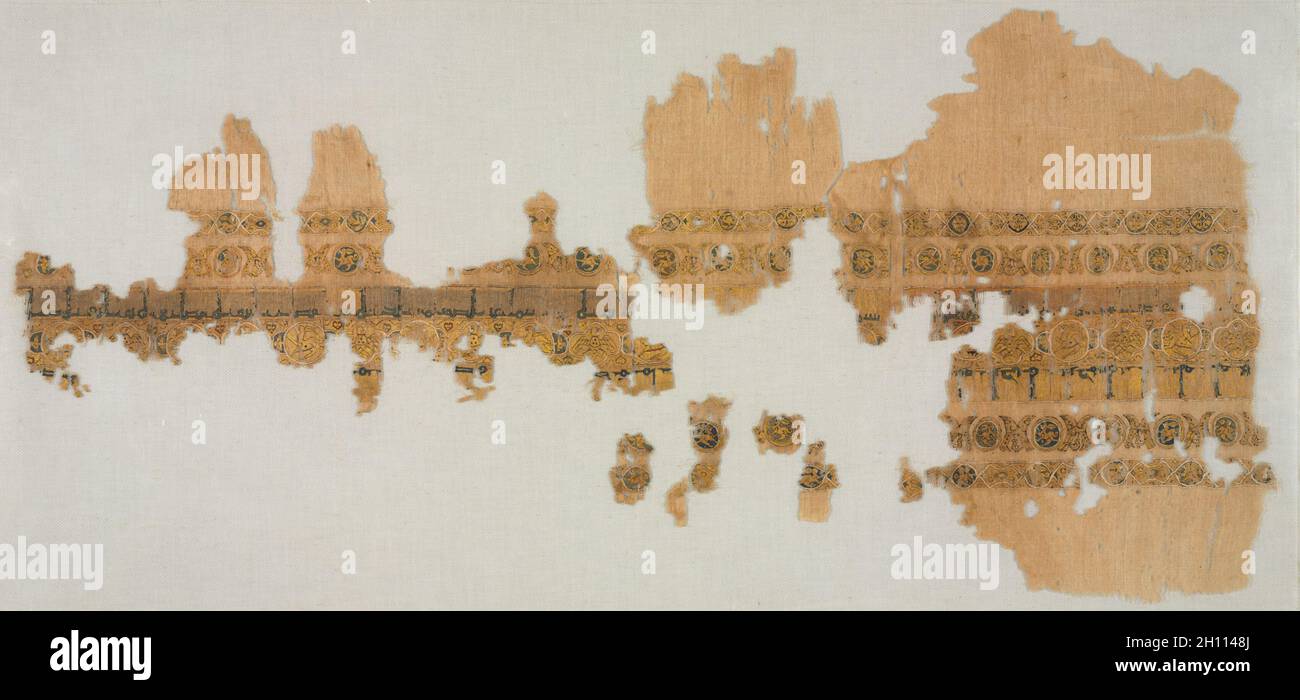 Tiraz with gold, 1094-1101. Egypt, Fatimid period, reign of Caliph al-Musta‘lī, 1094–1101. Plain weave with inwoven tapestry weave: linen, silk, and gold filé; overall: 36.8 x 91.4 cm (14 1/2 x 36 in.); mounted: 55.2 x 106.7 cm (21 3/4 x 42 in.). Stock Photo