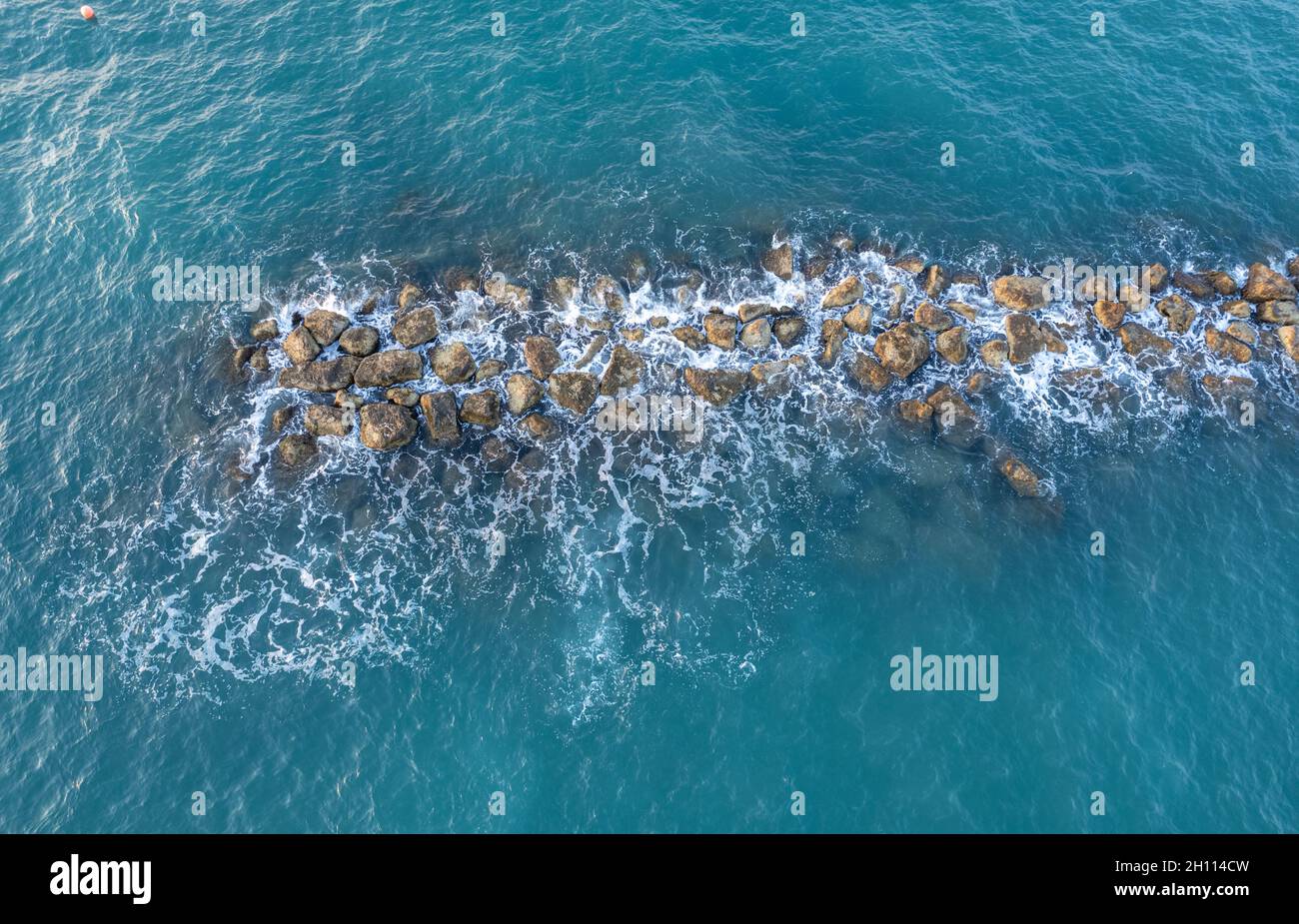 Aerial view from a flying drone of blue sea water and break water. Sea ...