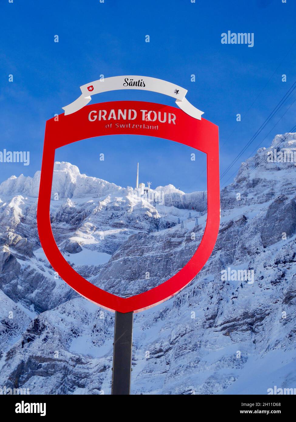 Mountain station of Saentis cable car seen through Grand Tour of Switzerland sign in winter. Appenzell, Switzerland. Stock Photo