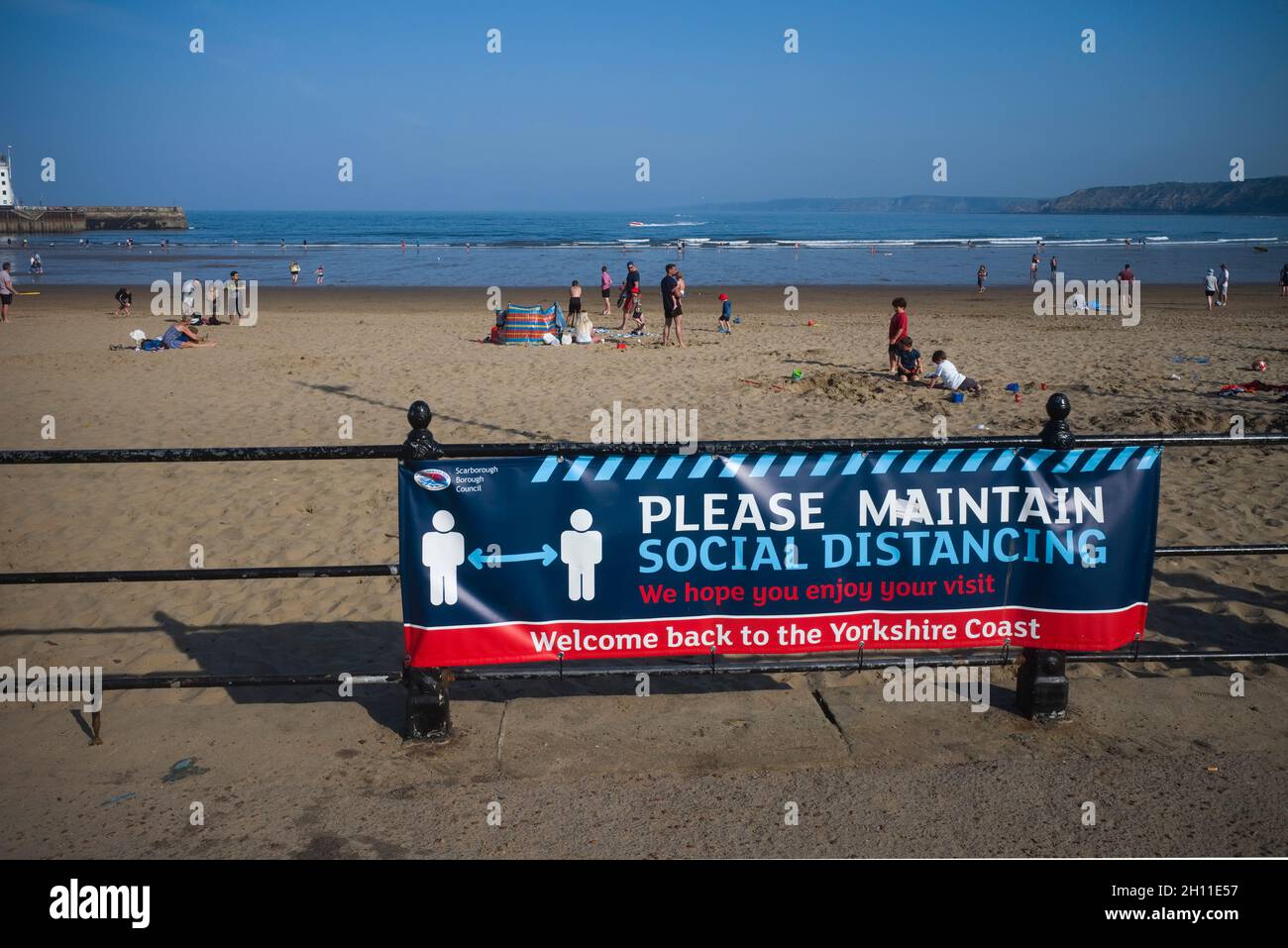 Poster on seaside railings in Scarborough asking people to maintain social distancing Stock Photo