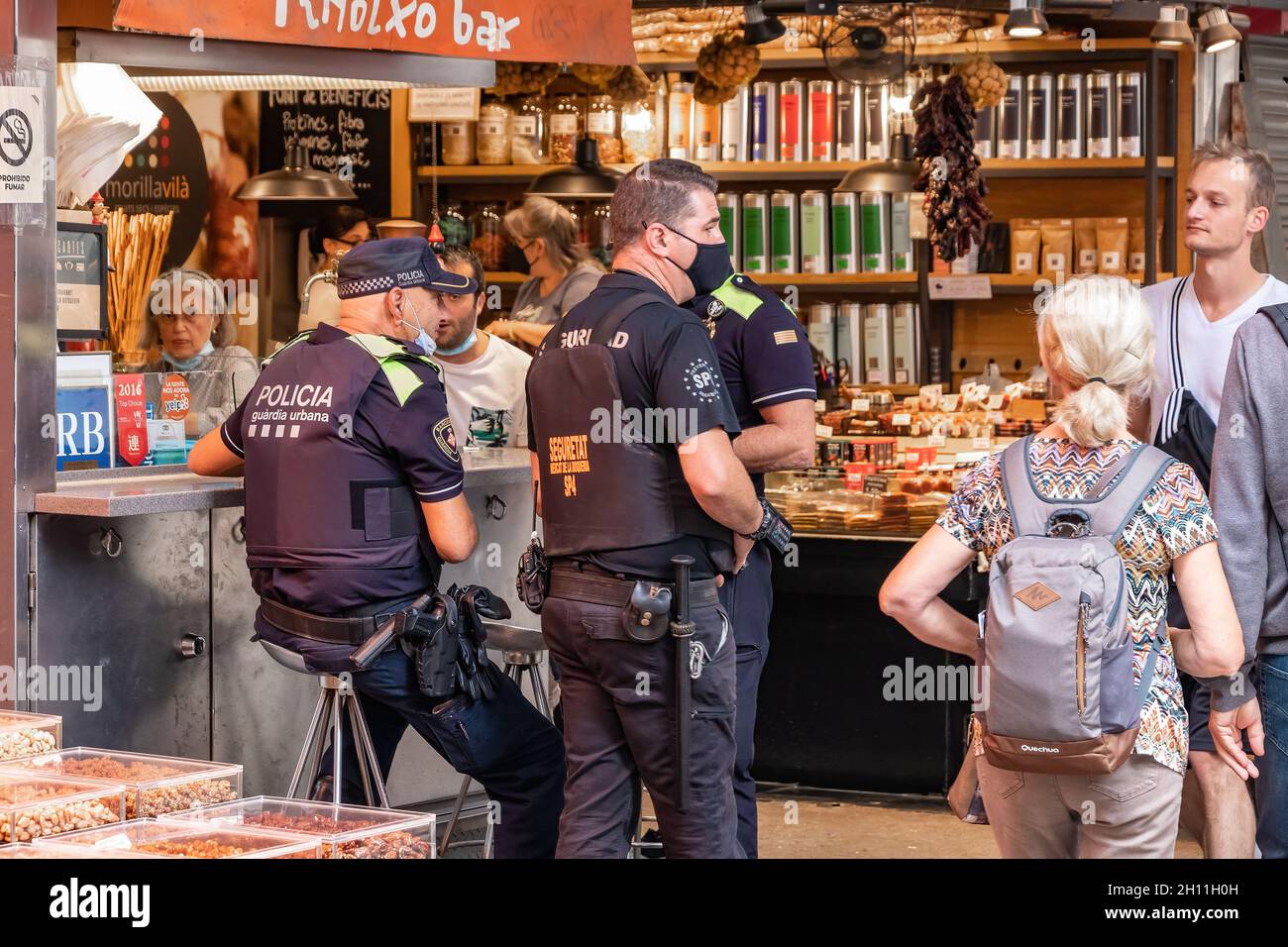 Barcelona, Spain - September 21, 2021: Barcelona Municipal Police, Guardia Urbana, and private security agent taking a rest Stock Photo
