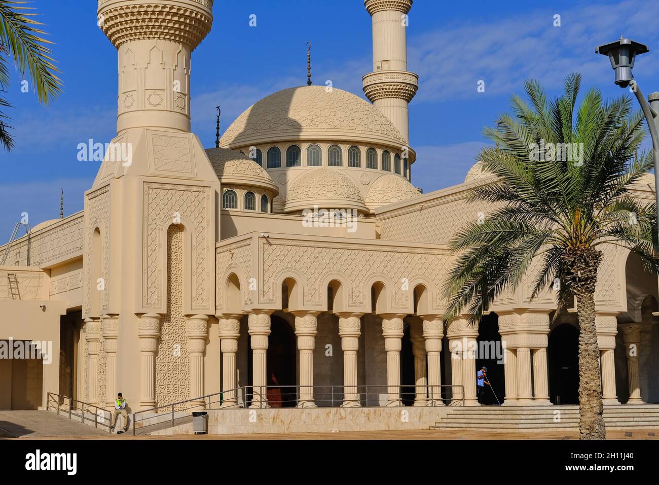 Ornate domes and minarets of Muslim islamic mosque in Abu Dhabi,UAE on background of blue sky. Minaret tower and roof cupola with traditional crescent Stock Photo