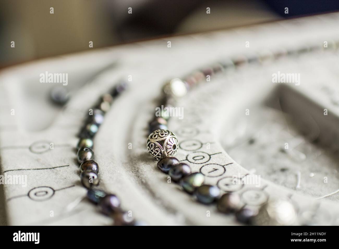 pearls and beads on bead design board Stock Photo Alamy