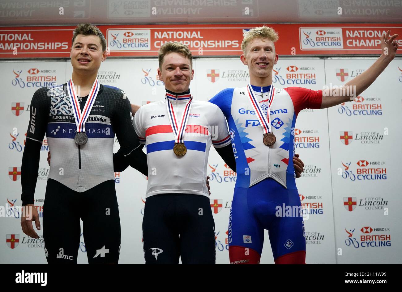 Harry Tanfield of Team Qhubeka Nexthash, second, Ethan Hayter of Team Ineos  Grenadiers, first, and Lewis Askey of GROUPAMA - FDJ, third, (left-right)  celebrate on the podium after the British Cycling National