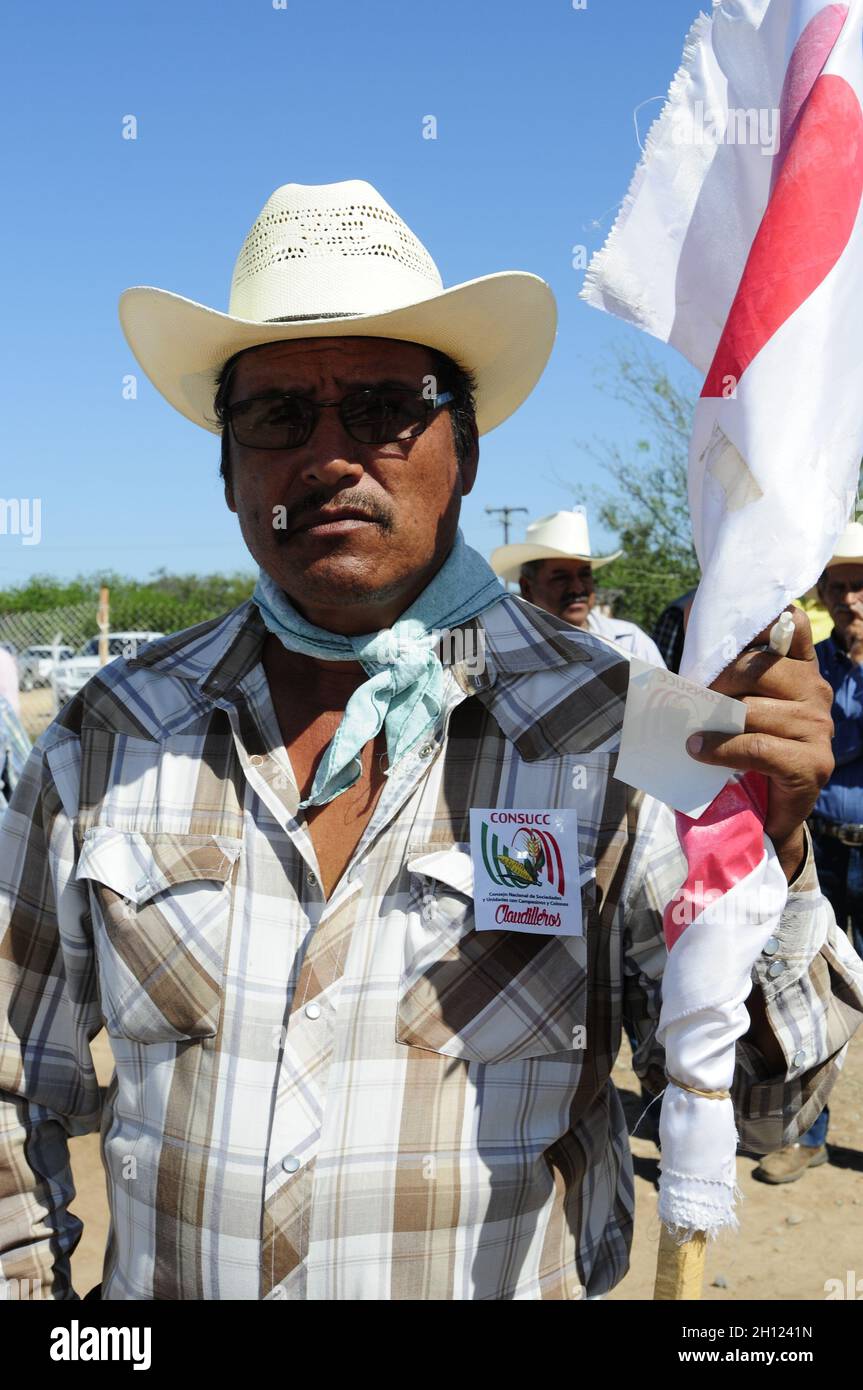 A Mayo man wears jeans and sunglasses while carrying the flag of CONSUC, the NATIONAL COUNCIL OF SOCIETIES AND UNITS WITH PEASANTS AND SETTLERS. Residents of the Agiabampo community, Sonora, Mexico. Agiabampo is a ranchería of the Municipality of Huatabampo located in the south of the Mexican state of Sonora ... (Photo by Isrrael Garnica / NortePhoto)  Un hombre Mayo viste vaquero y lentes de sol mientras porta la bandera  CONSUC, CONSEJO NACIONAL DE SOCIEDADES Y UNIDADES CON CAMPESINOS Y COLONOS. Pobladores de la comunidad  Agiabampo, Sonora, Mexico. Agiabampo es una ranchería del Municipio d Stock Photo