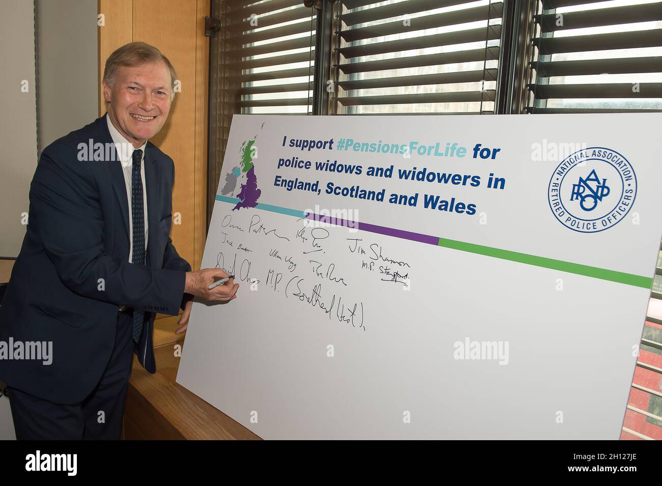 London, UK. 1st May, 2019. Sir David Amess MP for Southend West signs his support for the Pensions for Life for police widows and widowers in England, Scotland and Wales at a Parliamentary Drop-In at Portcullis House. Obituary: Sir David was tragically stabbed to death in his constituency on Friday 15th October 2021. Sir David had been an MP since 1983. Credit: Maureen McLean/Alamy Stock Photo