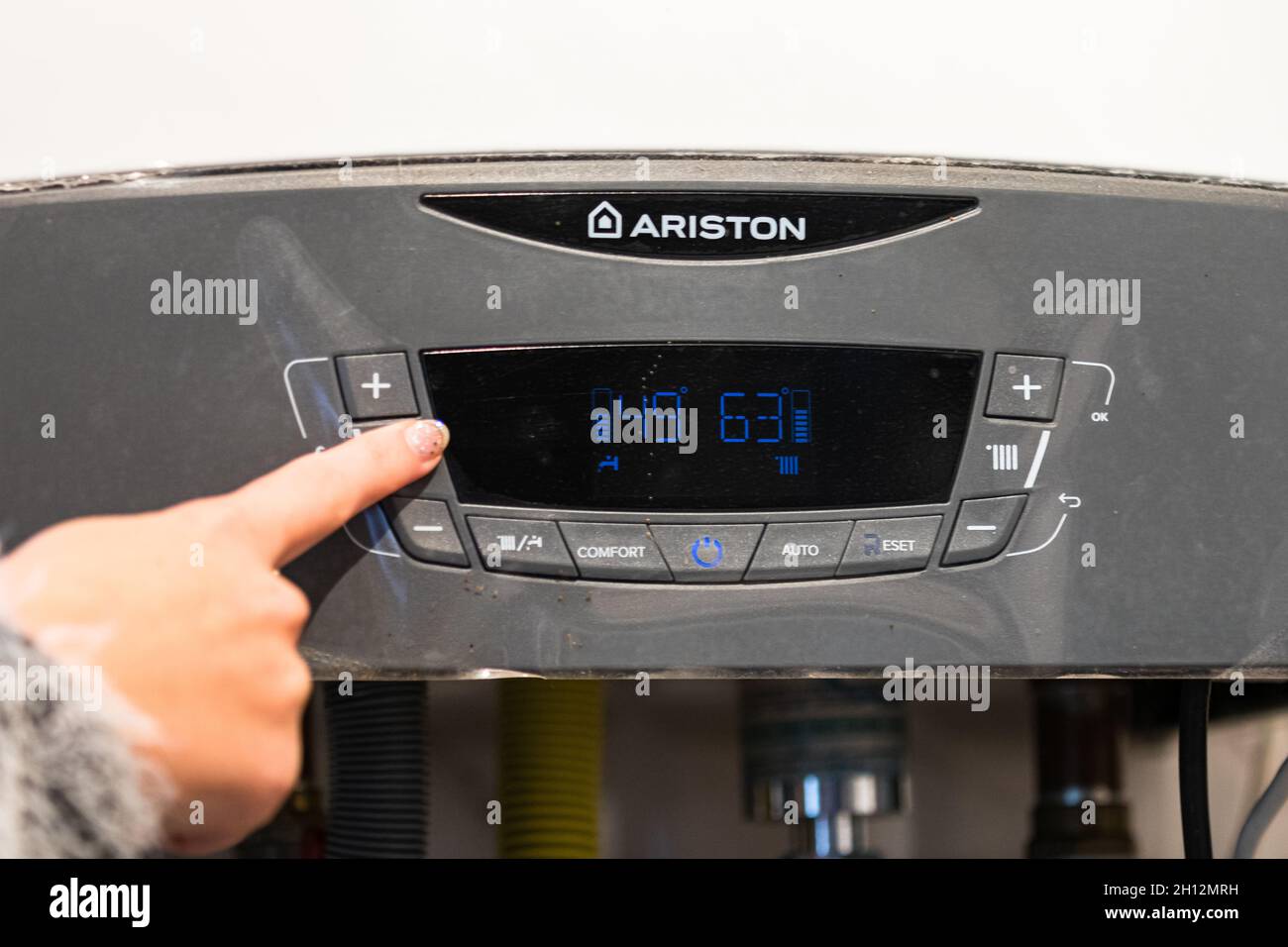 Girl hand setting temperature to heating system. Central heating