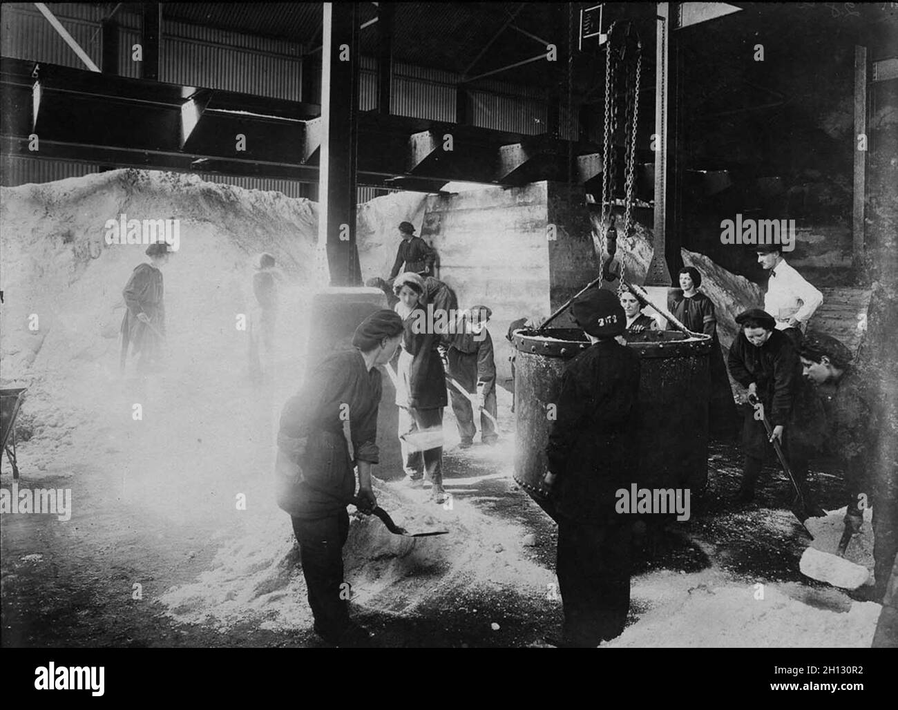 Women shovel nitrate of soda into a skip in a factory during WW1. Stock Photo