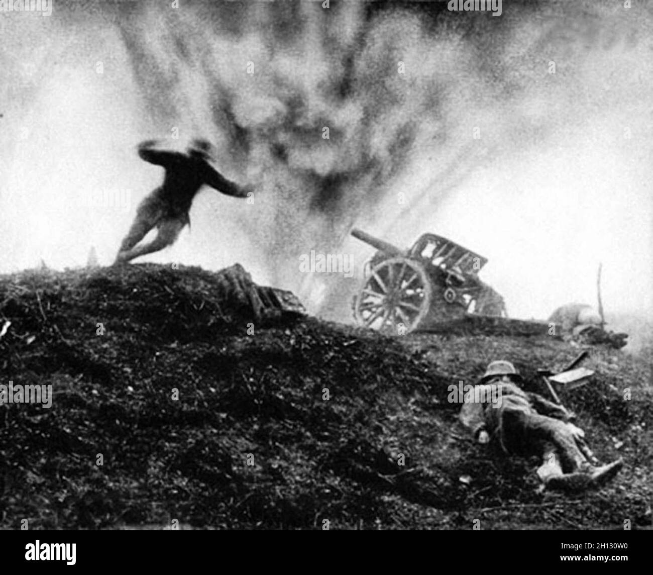 German soldier dives for cover as shell explodes behind him at an artillery position, 1917 Stock Photo