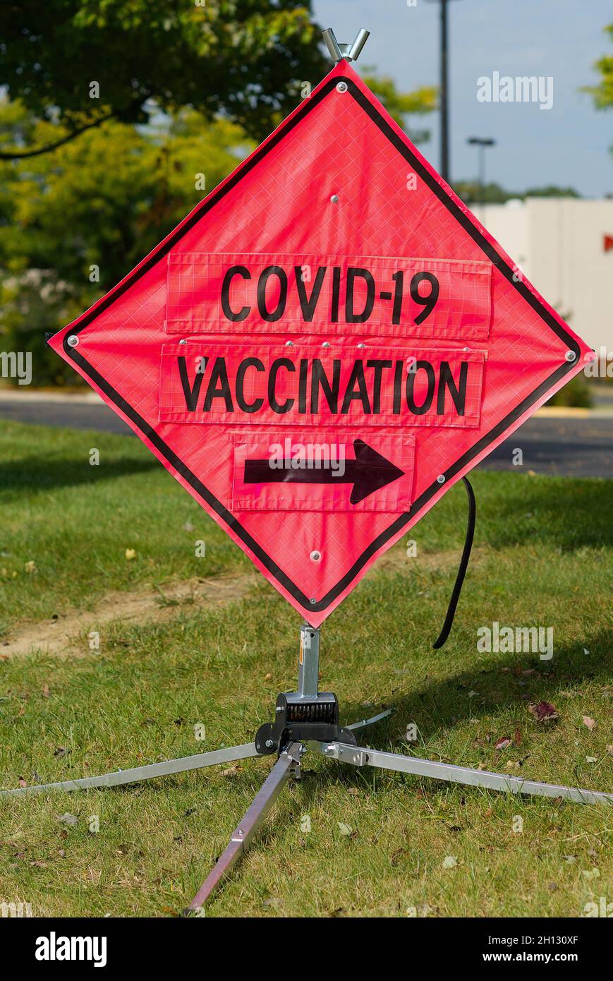 Woodbridge, Virginia, USA - October 15, 2021: A bright orange 'construction' sign shows drivers the entrance to a public COVID-19 vaccination site. Stock Photo