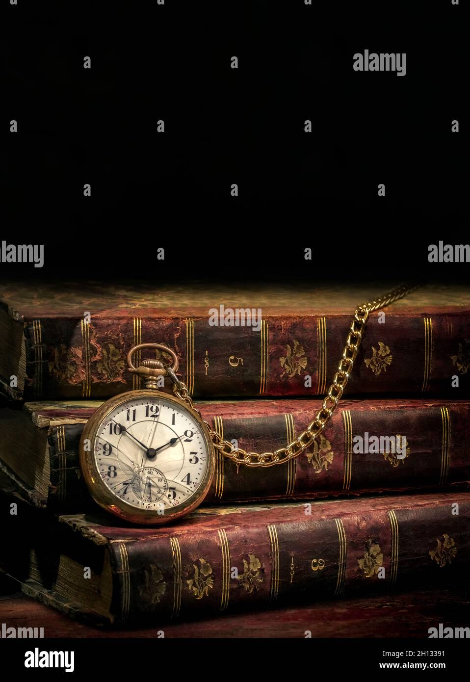 Vintage Antique pocket watch and old books on black background Stock Photo