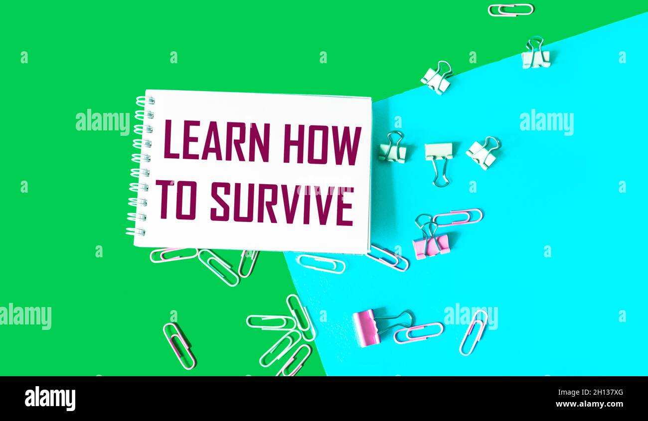 Text on Notepad Learn How to Survive. Survival in times of crisis business concept. Survival during an epidemic healthcare concept. Stock Photo