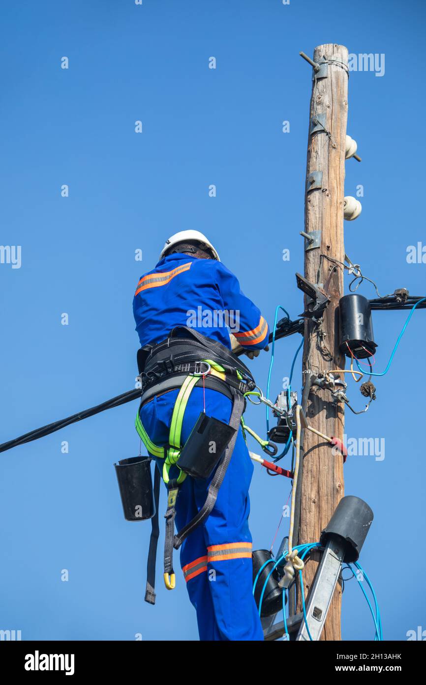 Motswana electrician worker in a Botswana , working on a pole to repair a fault Stock Photo
