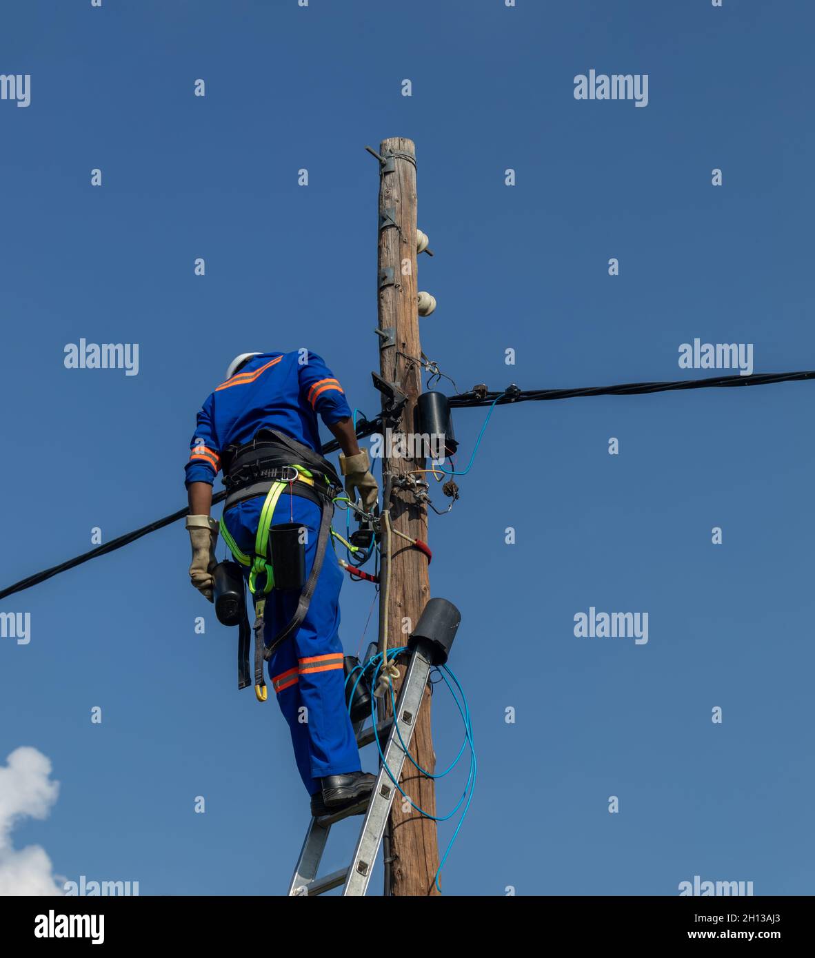 Motswana electrician worker in a Botswana , working on a pole to repair a fault Stock Photo