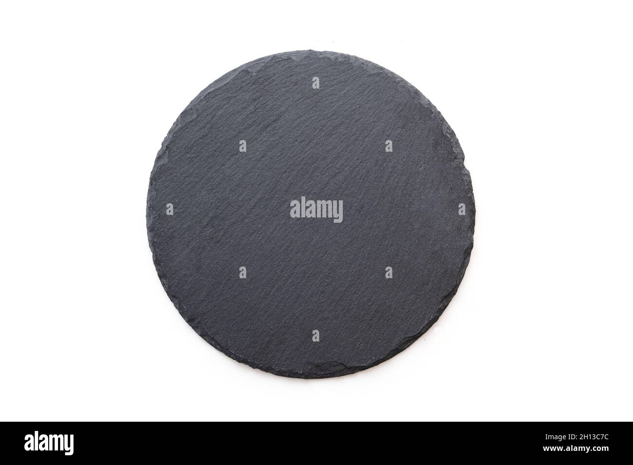 Round slate plate, black slate board isolated on white. Top view Stock Photo