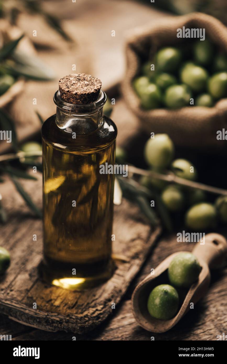 Green olives and olive oil in a bottle close up Stock Photo - Alamy