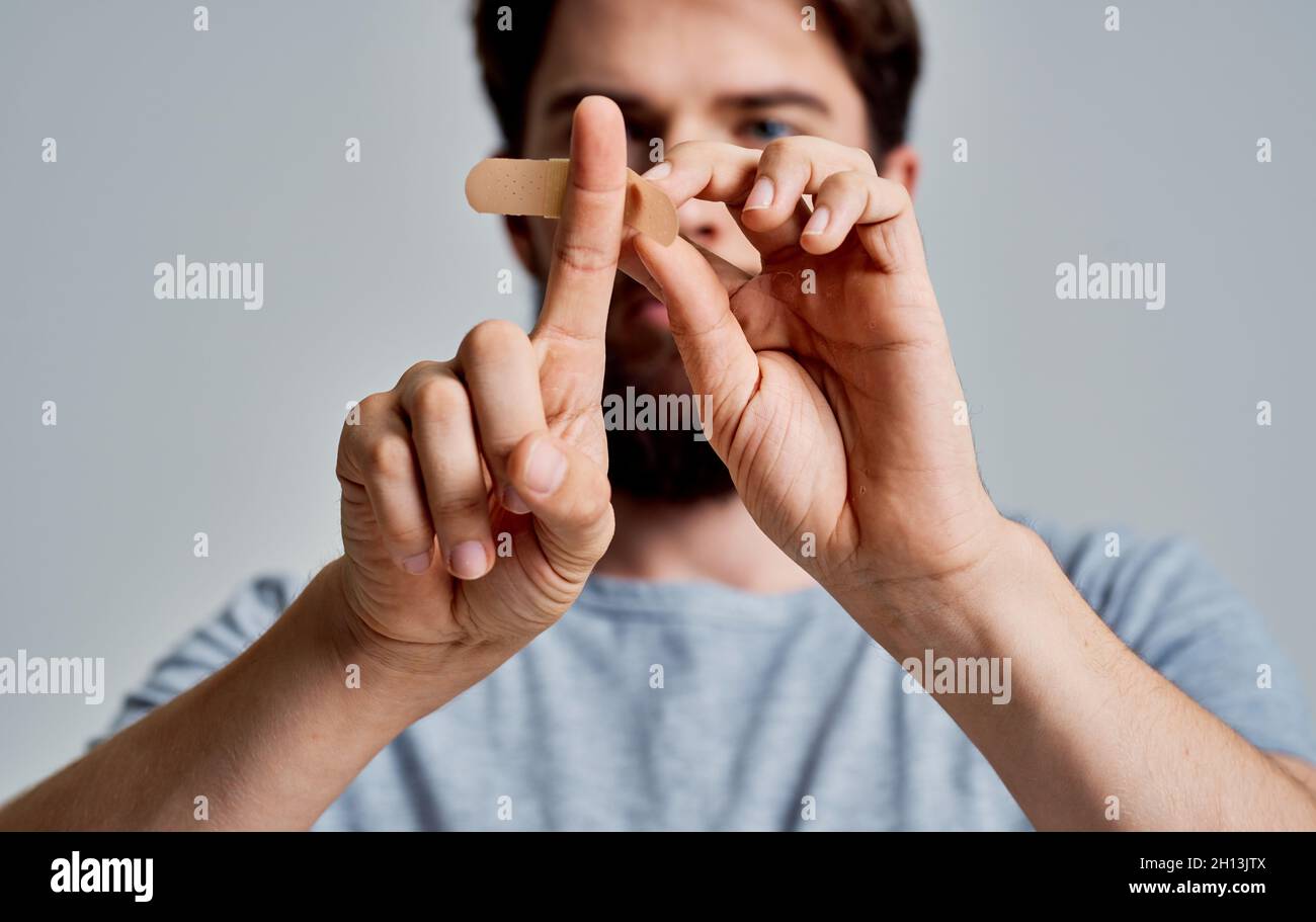 bearded man sticks his finger with a plaster treating health problems