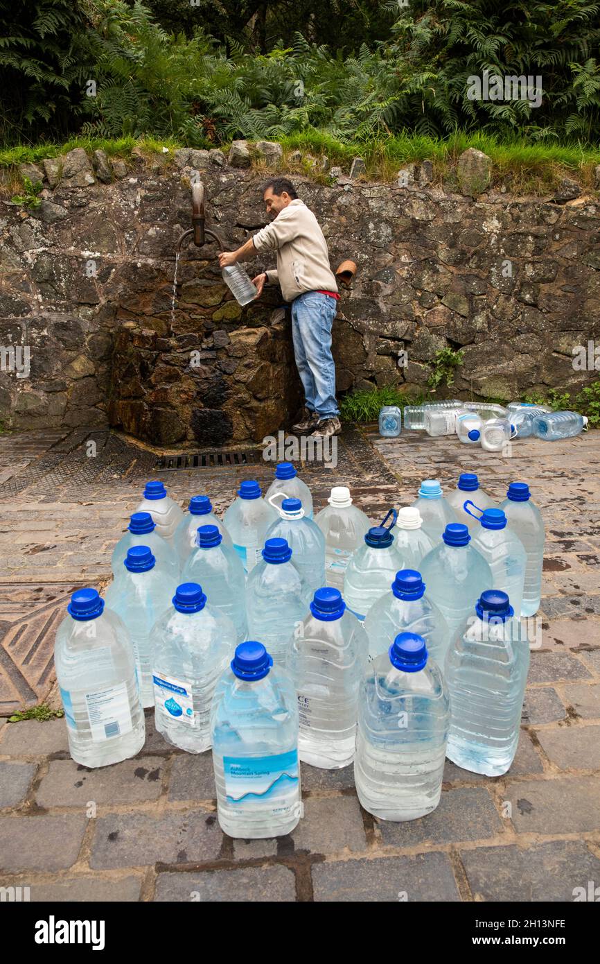 UK, England, Worcestershire, West Malvern, man at spout filling gallon bottles with water at Hay Slad Spring Stock Photo