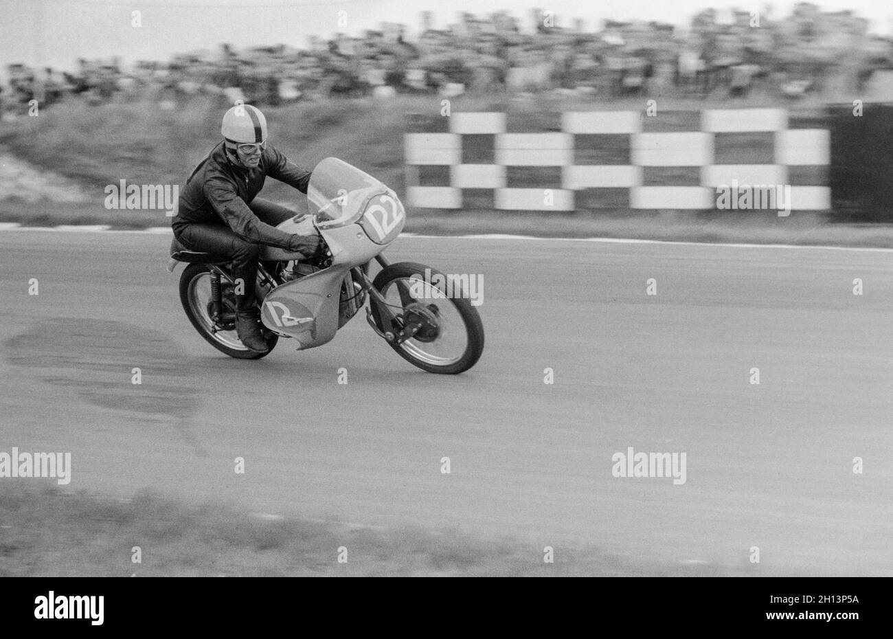 A vintage black and white photograph taken at Brands Hatch Race Circuit in England in 1961. Richard Wyler driving a Greeves Motorcycle. Stock Photo