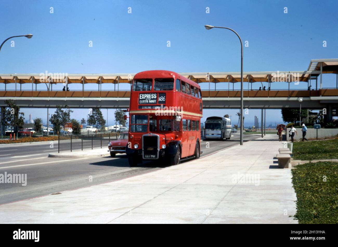 A traditional, London double-decker bus in Long Beach, California, USA in 1972. The bus was part of a small fleet (this bus is number 5) purchased by the Long Beach Public Transport Company to provide a service from downtown to Pierpoint Landing where RMS Queen Mary was moored. The ship, permanently moored at the port, is a tourist attraction featuring restaurants, a museum and a hotel. The red bus LLU 791 is an Leyland RTL model (RTL1037) dating from 1950. This image is from an old American amateur Kodak colour transparency – a vintage 1970s photograph. Stock Photo