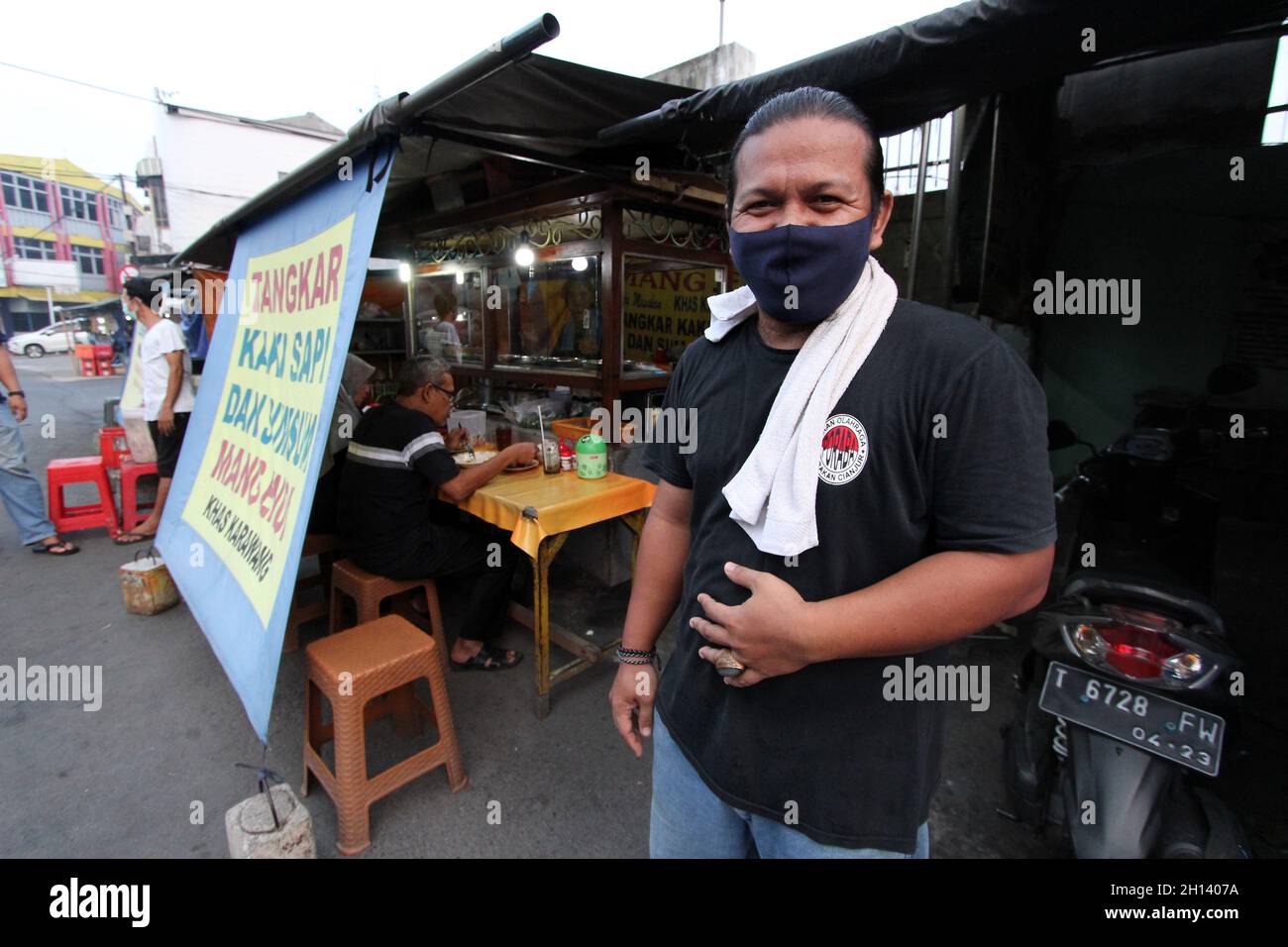 Karawang, Indonesia. 15th Oct, 2021. Yayan, 37, he is one of the sons of the owner of Warung Soto Tangkar Mang Endi who has been selling since the 1970s, poses for a photo at the legendary food stall Soto Tangkar typical of Karawang on Jalan Dewi Sartika, West Karawang, Karawang, West Java, Indonesia. This soto dish uses beef ribs and beef leg veins seasoned with turmeric and chili. It tastes savory and slightly sweet. Interestingly, this delicious dish is cooked traditionally. Almost all ingredients are steamed in a pot over coals of firewood. The growth of micro, small and medium enterprises Stock Photo