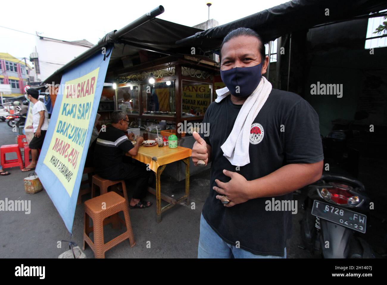 Karawang, Indonesia. 15th Oct, 2021. Yayan, 37, he is one of the sons of the owner of Warung Soto Tangkar Mang Endi who has been selling since the 1970s, poses for a photo at the legendary food stall Soto Tangkar typical of Karawang on Jalan Dewi Sartika, West Karawang, Karawang, West Java, Indonesia. This soto dish uses beef ribs and beef leg veins seasoned with turmeric and chili. It tastes savory and slightly sweet. Interestingly, this delicious dish is cooked traditionally. Almost all ingredients are steamed in a pot over coals of firewood. The growth of micro, small and medium enterprises Stock Photo