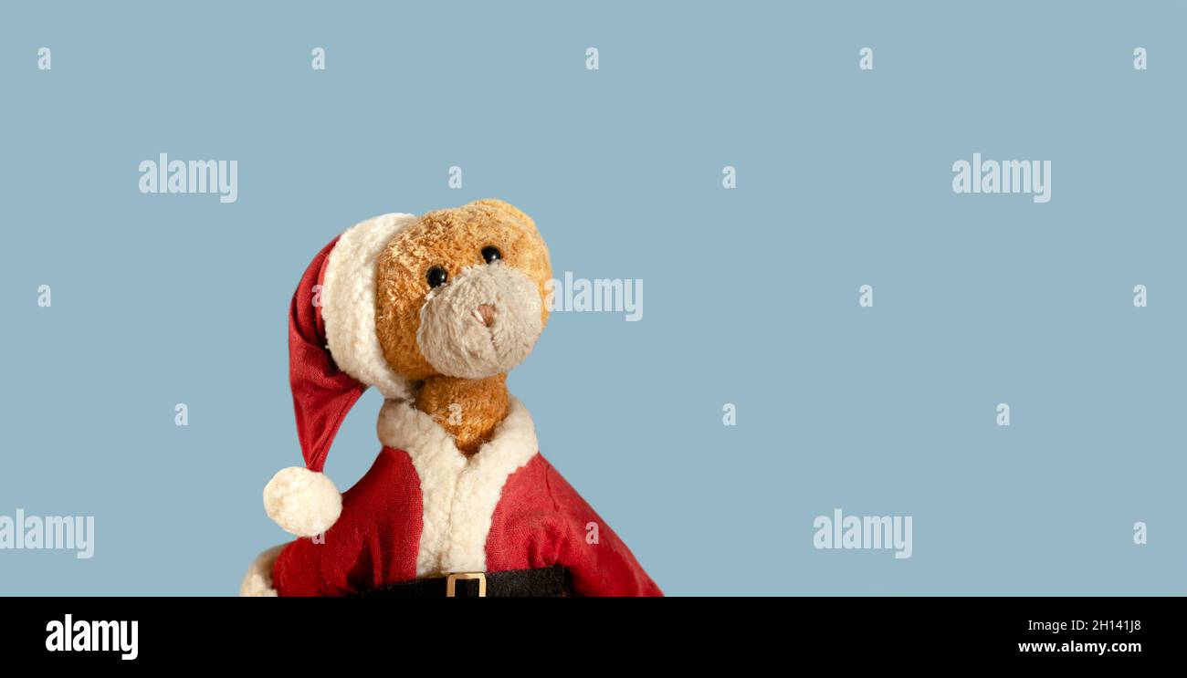 Vintage Santa Claus teddy bear isolated on light blue background. Christmas teddy bear. Empty space for text. Stock Photo