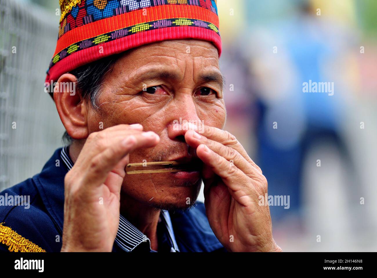 A Dusun ethnic man from Kiulu, Sabah, Malaysia, demonstrates playing the traditional musical instrument Turiding. Stock Photo