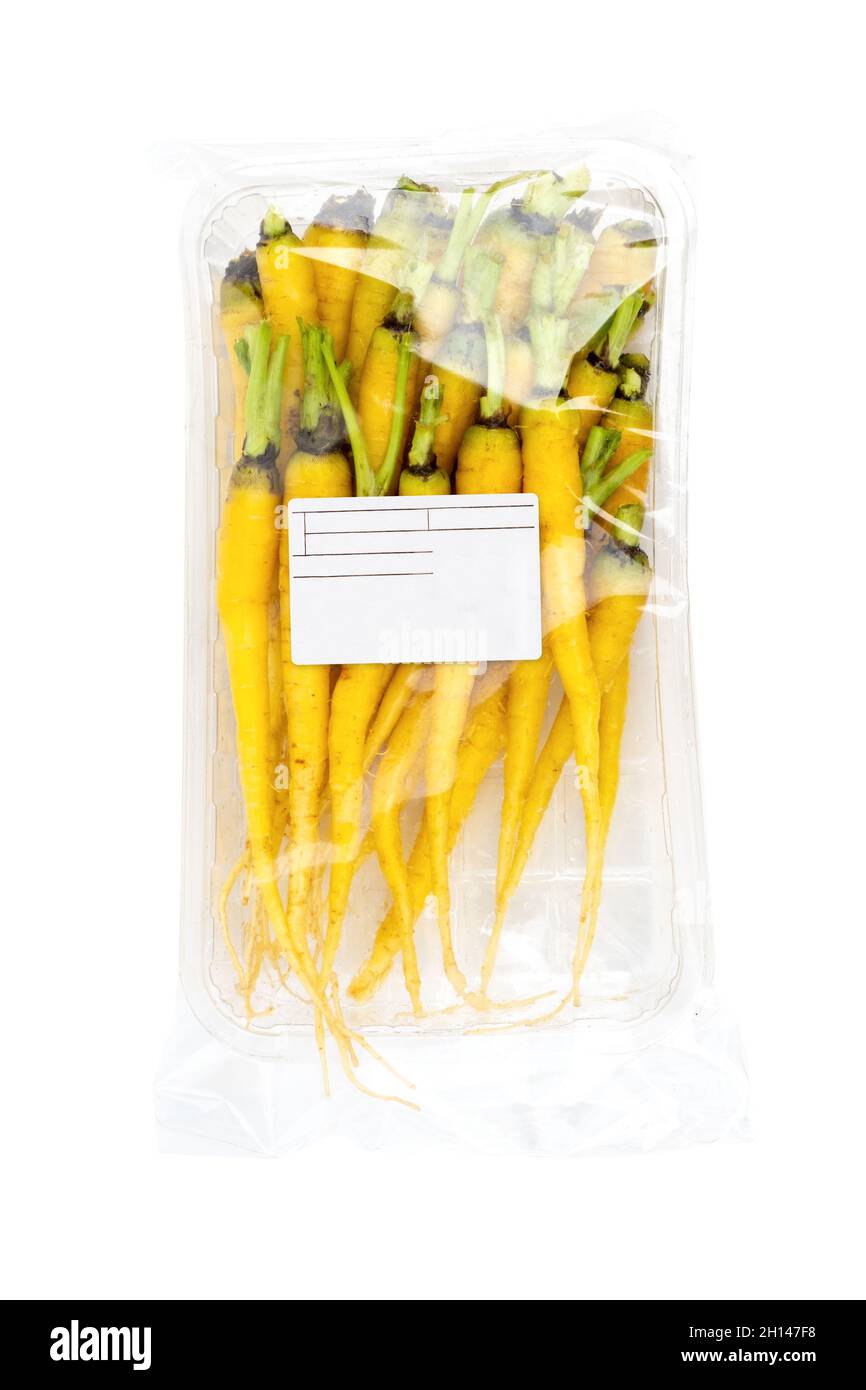 Mini yellow carrots in labeled packaging on a white background Stock Photo