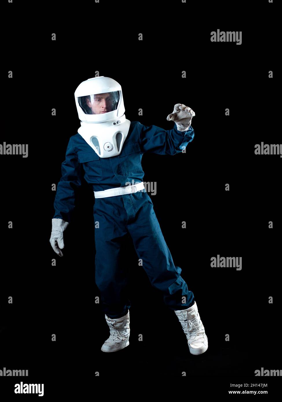 An astronaut in weightlessness reaches up with his hand. The hero of the science fiction story is a pioneer of space exploration. A young man in a spa Stock Photo